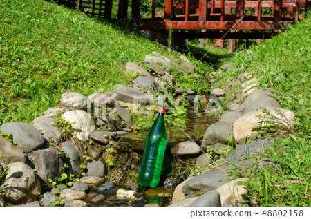 Bottle of water in a brook Bottle of water in a brook 48802158