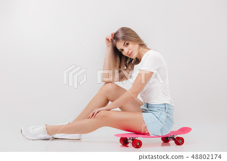 beautiful woman in white t-shirt with pink skateboard beautiful woman in white t-shirt with pink skateboard 48802174