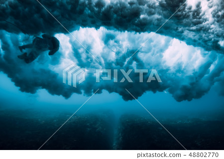 Surfer woman dive underwater under wave Surfer woman dive underwater under wave 48802770