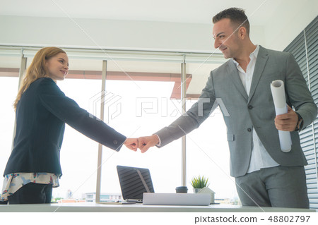 Business man and woman couple fist bump together f 48802797