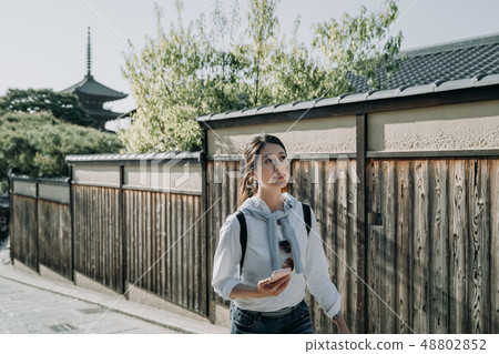 young woman backpacker holding smart phone young woman backpacker holding smart phone 48802852