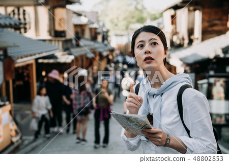 woman tourist holding map pointing to direction woman tourist holding map pointing to direction 48802853