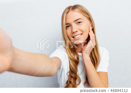 a beautiful girl dressed in a white t-shirt 48804112