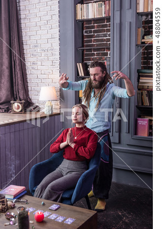 Nice long haired man performing a magic ritual 48804559