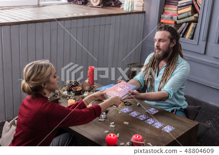 Nice serious man giving a book to his client 48804609