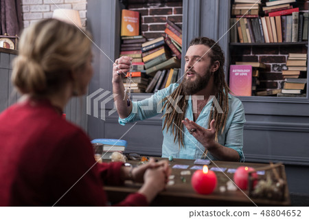 Positive bearded man presenting a special amulet 48804652