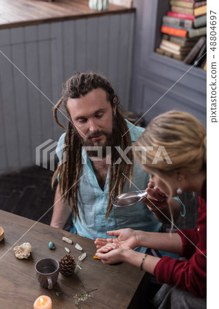 Nice bearded man holding a spoon with liquid 48804697