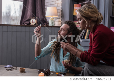 Positive bearded man looking at the crystal 48804725