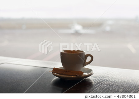 Cup of coffee on the table in airport cafe. 48804801