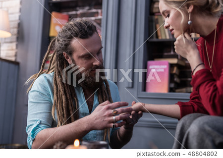 Positive bearded man working as a chiromancer 48804802