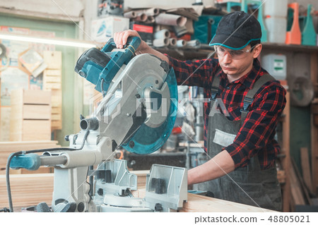 Construction worker cutting wooden board Construction worker cutting wooden board 48805021
