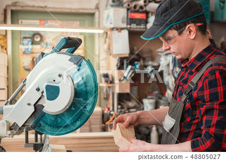 Construction worker cutting wooden board Construction worker cutting wooden board 48805027