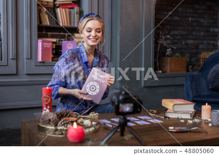 Happy nice woman showing her book to viewers Happy nice woman showing her book to viewers 48805060