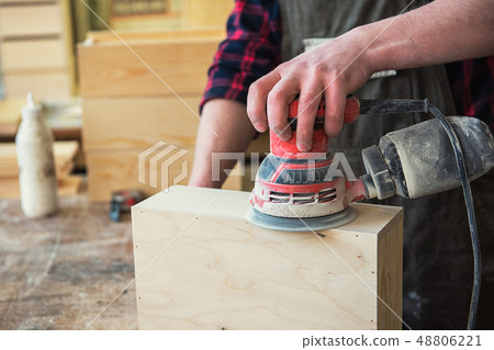 Worker grinds the wood box 48806221