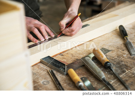 The worker makes measurements of a wooden board The worker makes measurements of a wooden board 48806314