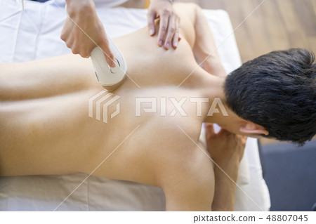 美容男性辦公室工作人員,他的背部永久脫毛成為美麗的皮膚 美容男性辦公室工作人員,他的背部永久脫毛成為美麗的皮膚 48807045