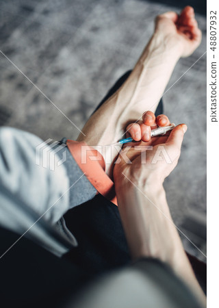 Male person doing an injection dose in the arm 48807932