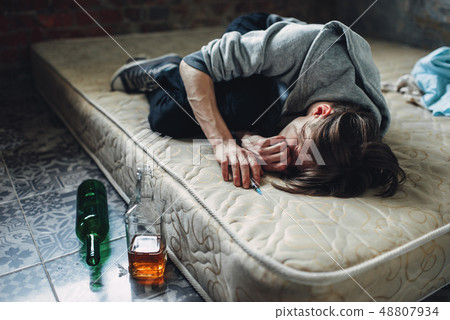 Druggy sleeping, bottle of alcohol is near 48807934