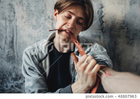 Male junkie with syringe doing an injection dose Male junkie with syringe doing an injection dose 48807963