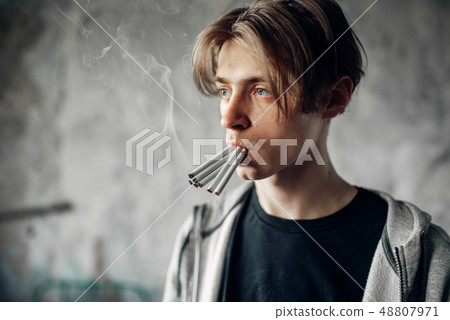 Young junkie with many cigarettes in his mouth 48807971