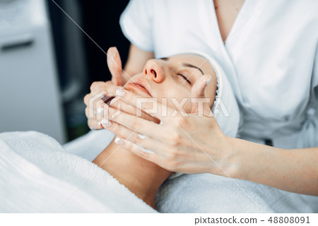 Face massage to female patient, cosmetology clinic 48808091