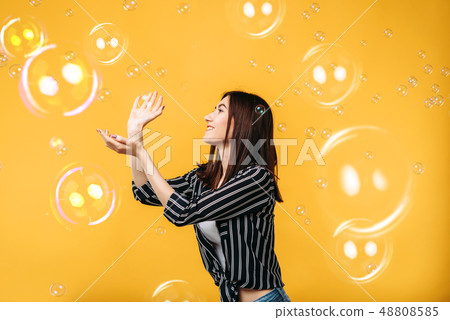 Pretty woman catches soap bubble Pretty woman catches soap bubble 48808585