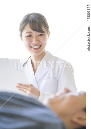 Angel female resident in white coat talking with patient with smile 48809135