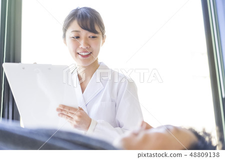 Angel female resident in white coat talking with patient with smile Angel female resident in white coat talking with patient with smile 48809138