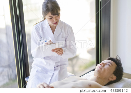 Angel female resident in cute white coat talking with patient with smile 48809142