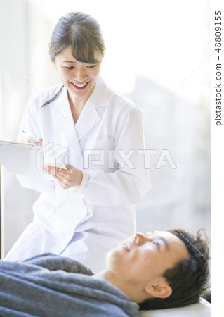 Angel female resident in white coat talking with patient with smile Angel female resident in white coat talking with patient with smile 48809155