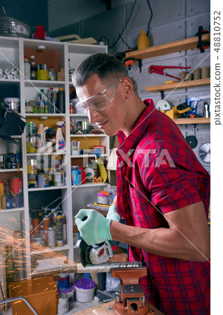 Locksmith cuts metal with a grinding machine, Mechanic power saw cuts. Locksmith cuts metal with a grinding machine, Mechanic power saw cuts. 48810752