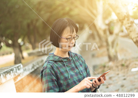 Asian mature woman using cellphone 48812299