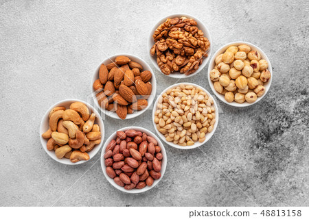 Assortment of nuts in white saucers  48813158