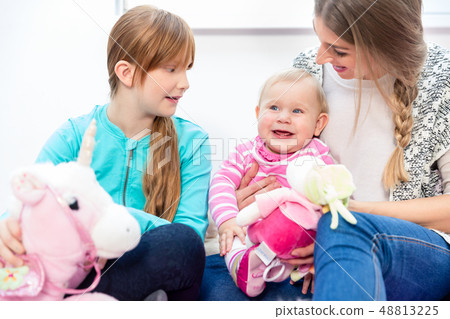 Girl and mother looking at happy baby 48813225
