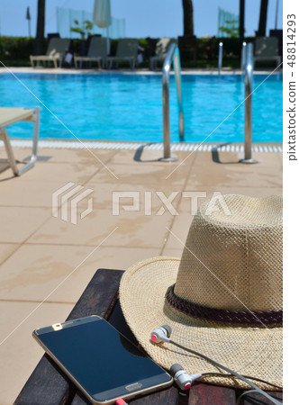 Hat with mobile phone and headphones on the green 48814293