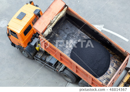 Heavy industrial dump truck unloading hot asphalt .City road construction and renewal site 48814367
