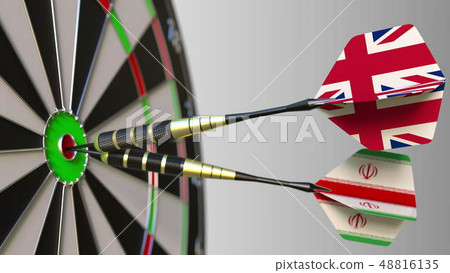 Flags of the United Kingdom and Iran on darts hitting bullseye of the target. International Flags of the United Kingdom and Iran on darts hitting bullseye of the target. International 48816135