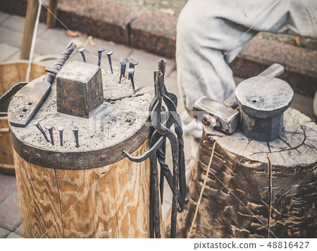 Metalworking tools of blacksmith. The hammer and the anvil and other tools outdoor green grass 48816427