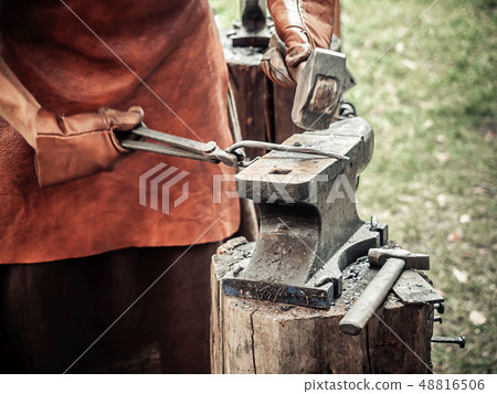 The blacksmith in the production process of metal products handmade on the openair workshop The blacksmith in the production process of metal products handmade on the openair workshop 48816506