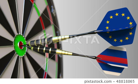 Flags of the European Union and Russia on darts hitting bullseye of the target. International 48818865