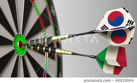 Flags of South Korea and Italy on darts hitting bullseye of the target. International cooperation or 48819004