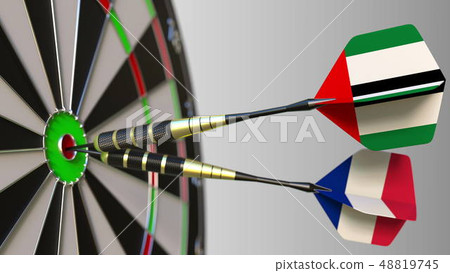 Flags of the UAE and France on darts hitting bullseye of the target. International cooperation or 48819745