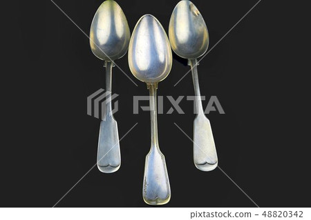 Old spoons on a black background. Three vintage spoons. Top view. Free space for text 48820342