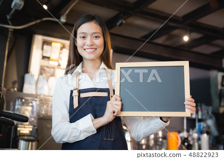Young asian women barista holding blank chalkboard Young asian women barista holding blank chalkboard 48822923
