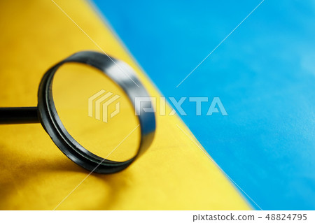 UKRAINE flag looking through a magnifying glass. 48824795