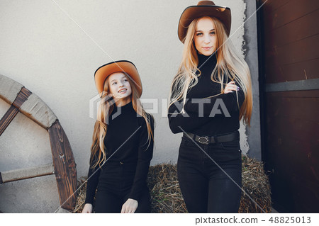 Girls in a cowboys hat on a ranch Girls in a cowboys hat on a ranch 48825013