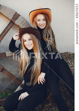 Girls in a cowboys hat on a ranch Girls in a cowboys hat on a ranch 48825015