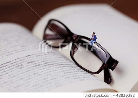 坐與書和放大鏡的一個人 坐與書和放大鏡的一個人 48829388