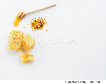Honey with dipper, honeycomb and bee pollen on white background Honey with dipper, honeycomb and bee pollen on white background 48829845