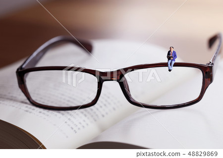 Men sitting in books and glasses Men sitting in books and glasses 48829869